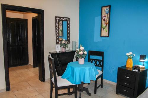 a dining room with a table and a blue wall at hotel plaza BRISAS MT in Punta Cana
