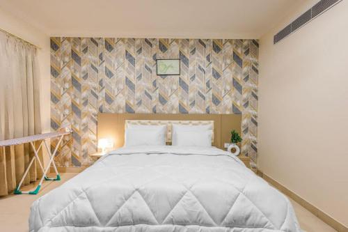 a bedroom with a large white bed and a wall at Eco-friendly vibes cozy space in Gurgaon