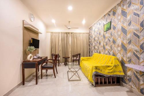 sypialnia z żółtym łóżkiem oraz stołem i krzesłami w obiekcie Nature-inspired luxury 1 BHK w mieście Gurgaon