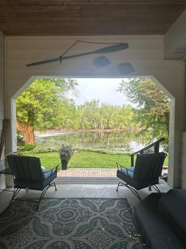 a screened in porch with two chairs and a view of a lake at Breezeway Bay - Waterfront Full House in Wisconsin Dells