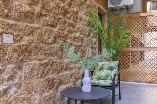 a vase sitting on a table next to a chair at Jade Guesthouse In The Old Souks in Batroûn
