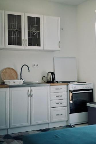 a kitchen with white cabinets and a stove top oven at Villa Pietra in Stolac