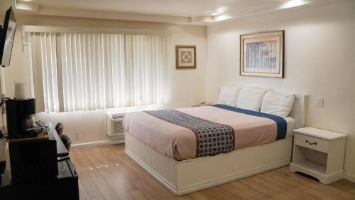 a bedroom with a bed and a large window at 777 Motor Inn in Sherman Oaks