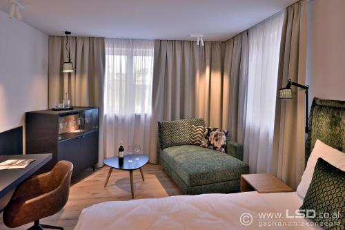 a hotel room with a bed and a couch and a table at Landhotel Atzmüller in Waxenberg