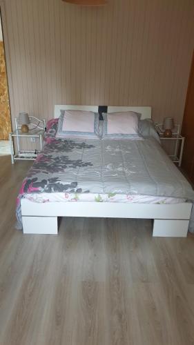 a bed in a bedroom with a wooden floor at Verdure tourangelle in Azay-sur-Cher