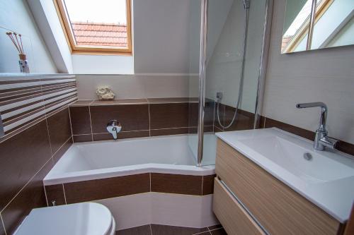 a bathroom with a tub and a toilet and a sink at Luxusní Vinařská Villa in Pavlov