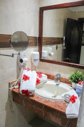 a bathroom with a sink with a mirror and towels at hotel plaza BRISAS MT in Punta Cana