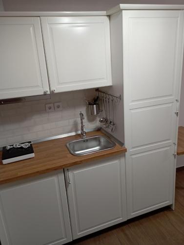 a kitchen with white cabinets and a sink at Storks apartments in Korinós