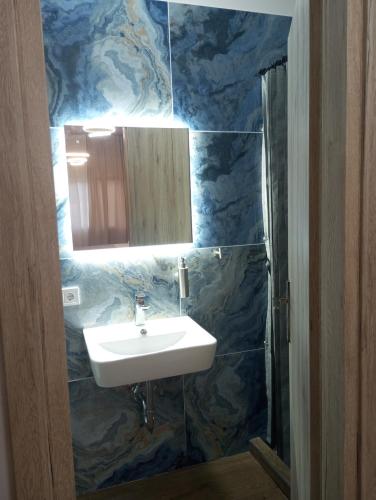 a bathroom with a sink and a blue marble wall at Storks apartments in Korinós