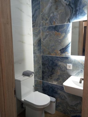 a bathroom with a toilet and a sink at Storks apartments in Korinós