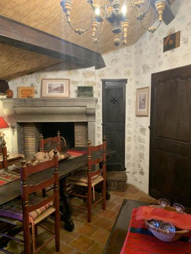 une salle à manger avec une table et une cheminée dans l'établissement La Sanglière, à Ampus