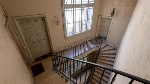 - un escalier dans un bâtiment avec une fenêtre et une porte dans l'établissement Le perchoir de la préfecture, à Montpellier