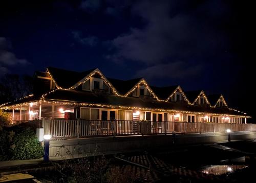 a house lit up at night with lights at Yare View Holiday Cottages in Brundall