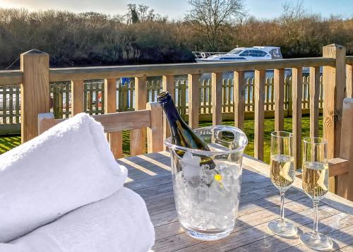 a table with wine glasses and a bottle of champagne at Yare View Holiday Cottages in Brundall