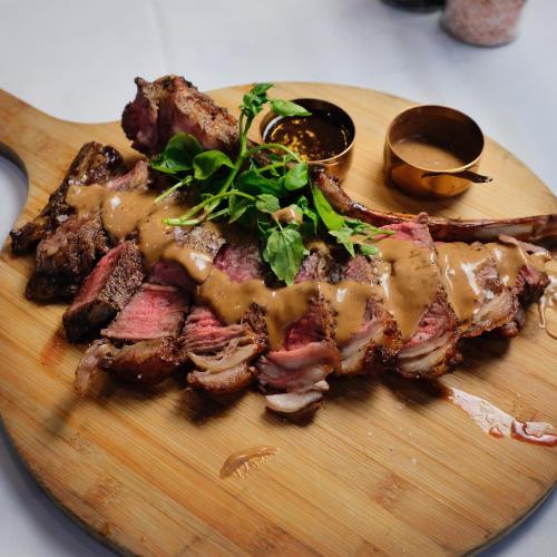 a plate of meat with sauce and greens on it at The Mount Country Manor Hotel & Golf Wolverhampton in Wolverhampton