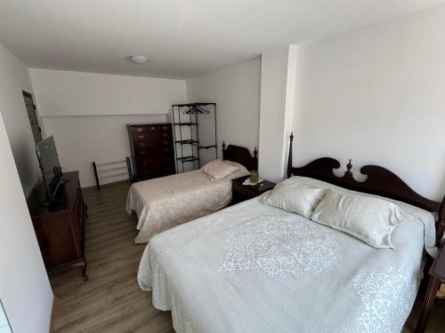 a bedroom with two beds and a dresser at Kultura Apartment in Skopje