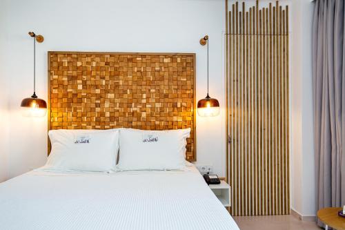 a bedroom with a large bed and a brick wall at Icon Suites by the sea in Potos