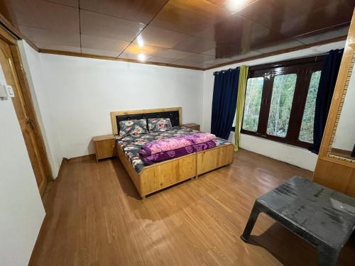 a bedroom with a bed and a table in it at Guru guest house in Leh