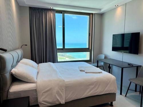 a hotel room with a bed and a large window at C Tower Premium Apartments, Panoramic Sea View in Netanya