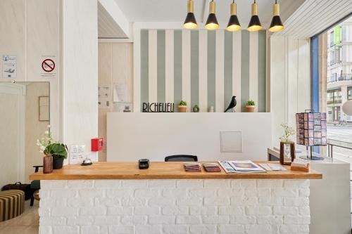un bureau avec un comptoir de réception avec un mur de briques dans l'établissement Hôtel Richelieu, Le Havre Centre-Ville, Perret, au Havre