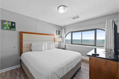 Ένα ή περισσότερα κρεβάτια σε δωμάτιο στο Capital O Sunset Waves Hotel Myrtle Beach Oceanfront
