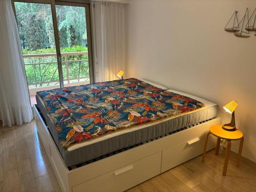 un grand lit dans une chambre avec une fenêtre dans l'établissement Le refuge varois, à Saint-Raphaël