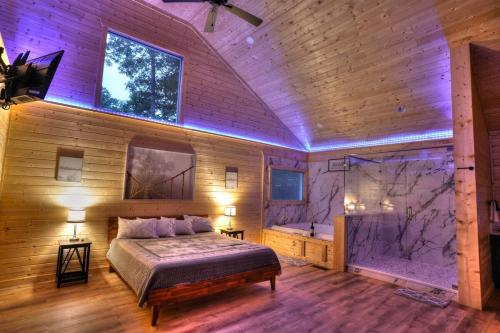 a bedroom with a bed and a tub in it at Brand New Luxury Cabin Full of Amenities 