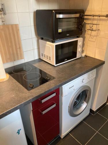d'un four micro-ondes et d'un lave-linge/sèche-linge dans la cuisine. dans l'établissement Studio meublé Gambetta, à Paris
