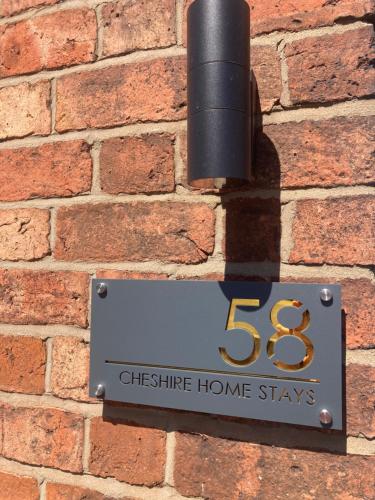 a sign on the side of a brick wall at Cheshire Home Stays in Church Coppenhall