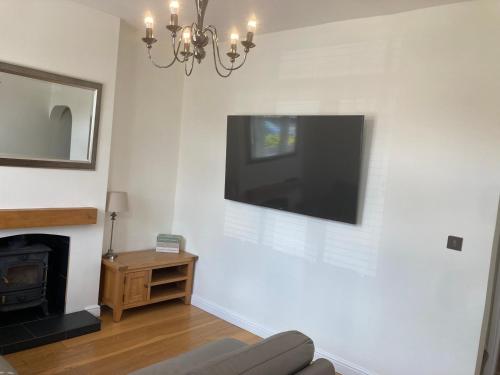 a living room with a flat screen tv on the wall at Cheshire Home Stays in Church Coppenhall