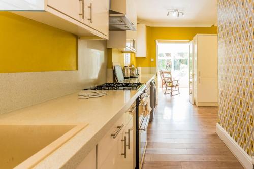 a kitchen with yellow walls and a counter top at Unique City Abode in Durham
