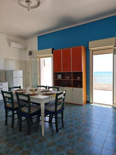 a kitchen with a table and chairs in a room at La terrazza di Adele in Scoglitti