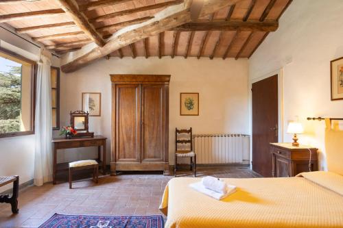 a bedroom with two beds and a desk at Borgo Villa Certano - Case Vacanza in Toscana in Siena