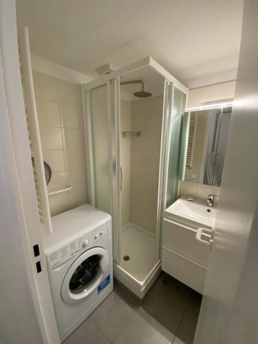 une salle de bain avec une machine à laver et un lavabo dans l'établissement Appartement LES PETITS PRINCES, à Agay