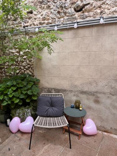 a chair and a table in front of a wall at Le nid d’Isa in Hautvillers