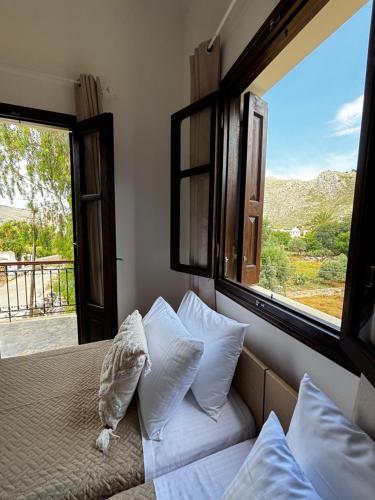 a bedroom with a bed with a large window at Amelia's Home in Symi