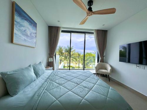 ein Schlafzimmer mit einem großen Bett und einem Deckenventilator in der Unterkunft Villa 95 3PN Sanctuary Ho Tram Resort in Hồ Tràm