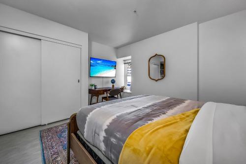 a bedroom with a large bed and a tv at Promenade Studio in Los Angeles