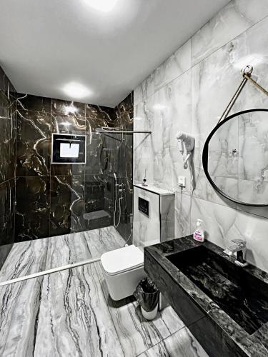 a black and white bathroom with a toilet and a sink at View of the Mountain in Gabala