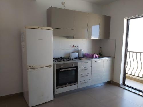 eine Küche mit einem weißen Kühlschrank und einem Herd in der Unterkunft Perfect value apartment in St Paul's Bay