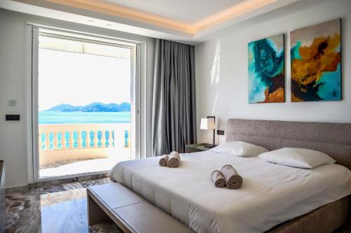 une chambre avec un lit avec deux paires de chaussures dessus dans l'établissement PALAIS MIRAMAR 65 BD DE LA CROISETTE CANNES, à Cannes