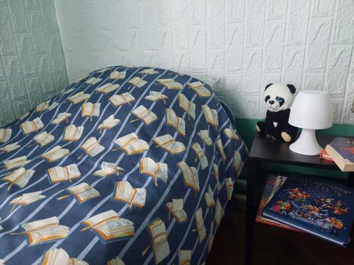 a bed with a blue comforter with books on it at Family House in Golubac