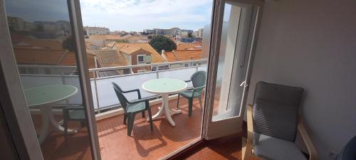 une chambre avec un balcon avec une table et des chaises dans l'établissement appt 4 personnes plage des demoiselles, à Saint-Hilaire-de-Riez