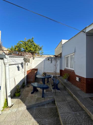 a patio with two picnic tables and a building at Departamento IRIS in Tandil