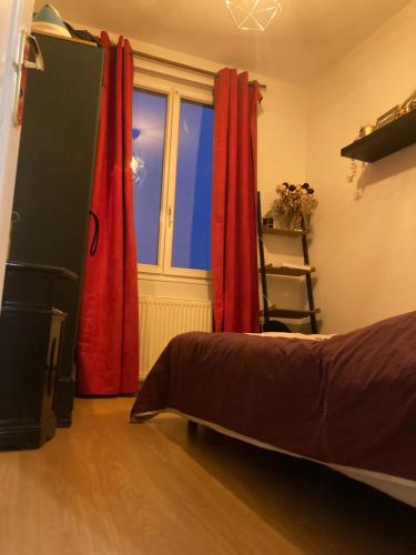 - une chambre avec des rideaux rouges, un lit et une fenêtre dans l'établissement Terra's House, à Rouen