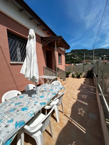 a table with an umbrella and chairs on a patio at Casa Marisa in Camporosso