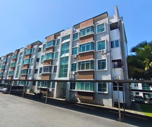 a large apartment building with a palm tree in front of it at A&M Budget Apt, 5mins to Airport, 8mins to KK City in Penampang