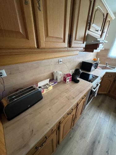 a kitchen with wooden cabinets and a counter top at La maison des amis in Beauvais