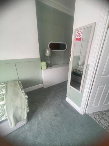 a small room with a bed and a mirror at Crockets Hotel in Newcastle upon Tyne
