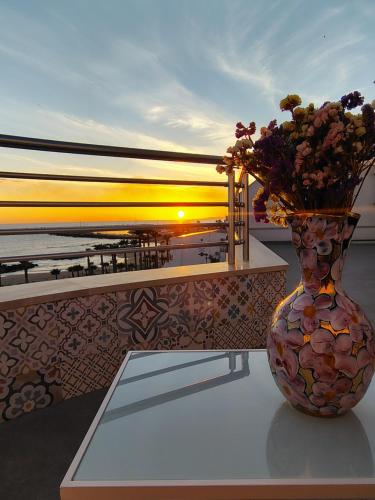 a vase with flowers in it sitting on a table at La terrazza di Adele in Scoglitti